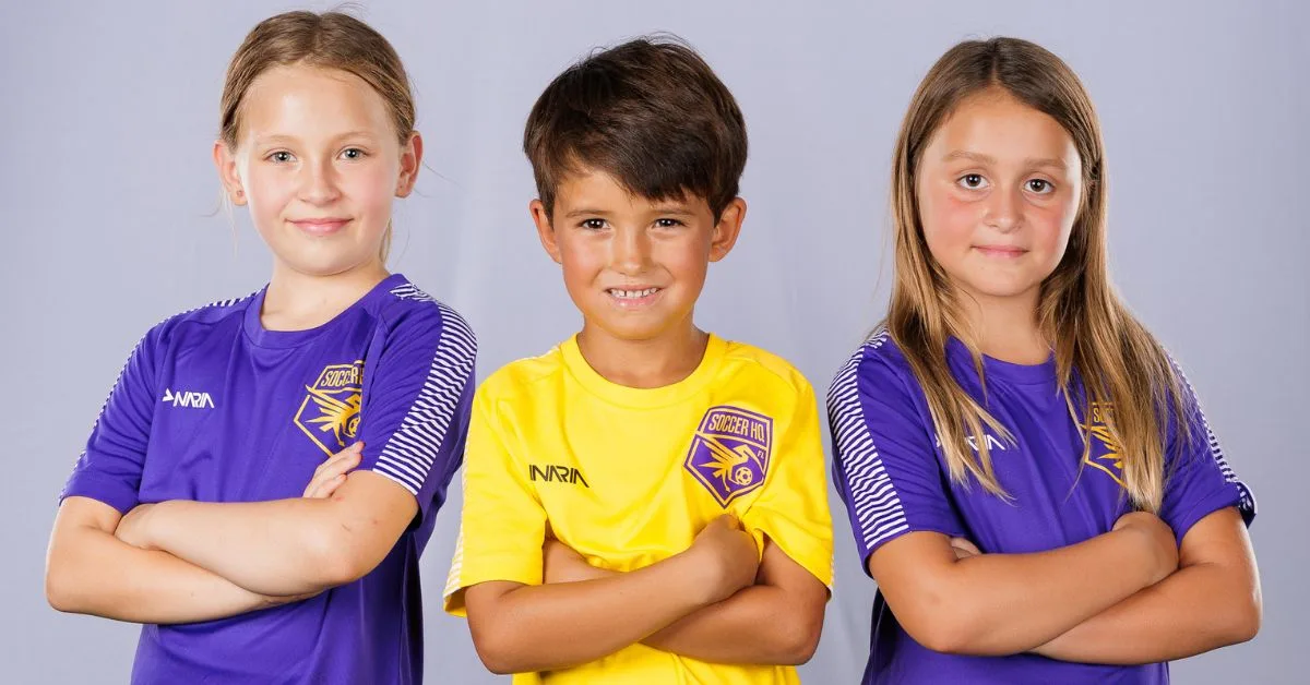 Three Soccer HQ players in team jerseys, arms crossed and smiling
