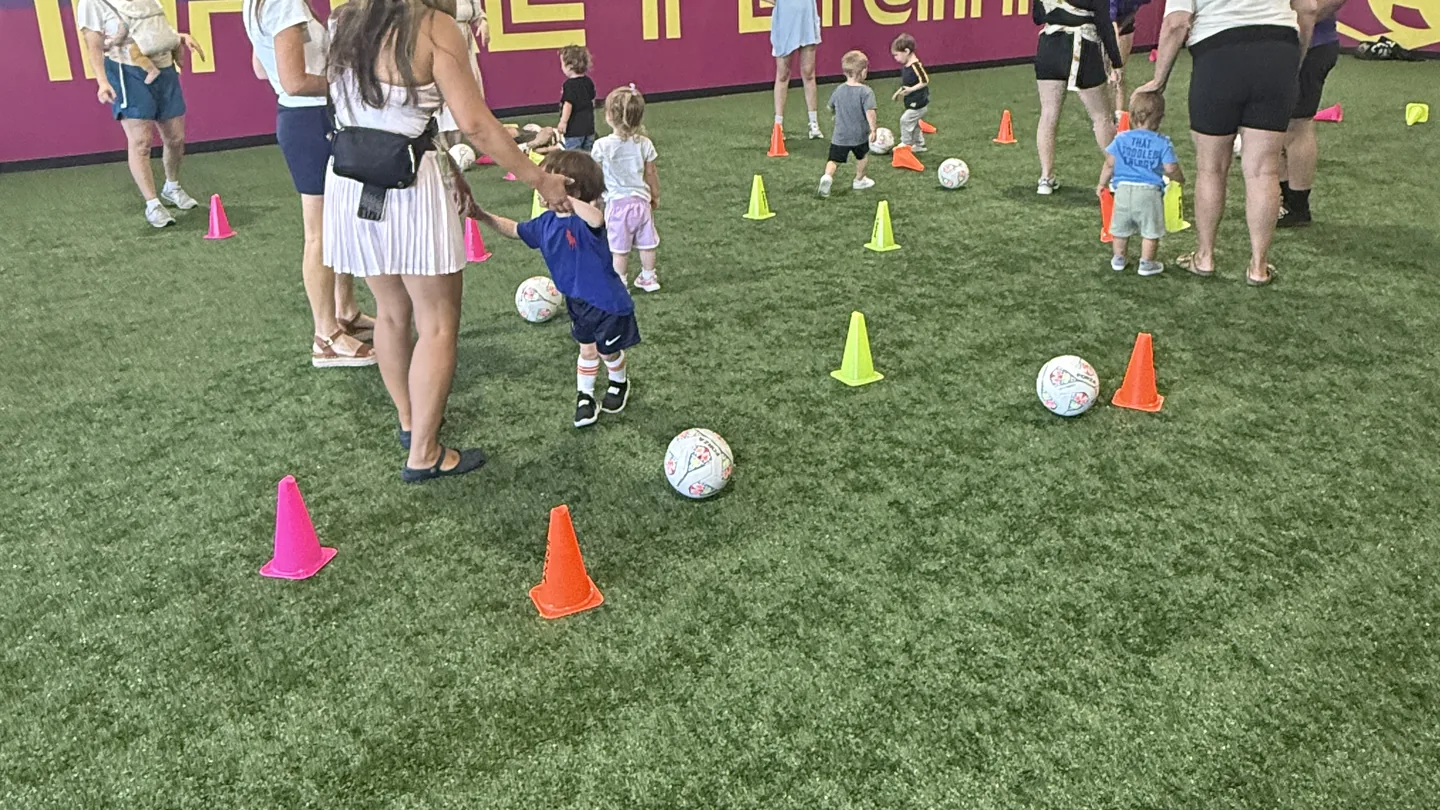 A small group of toddlers, parents, and coaches during a Mini Movers class at Soccer HQ