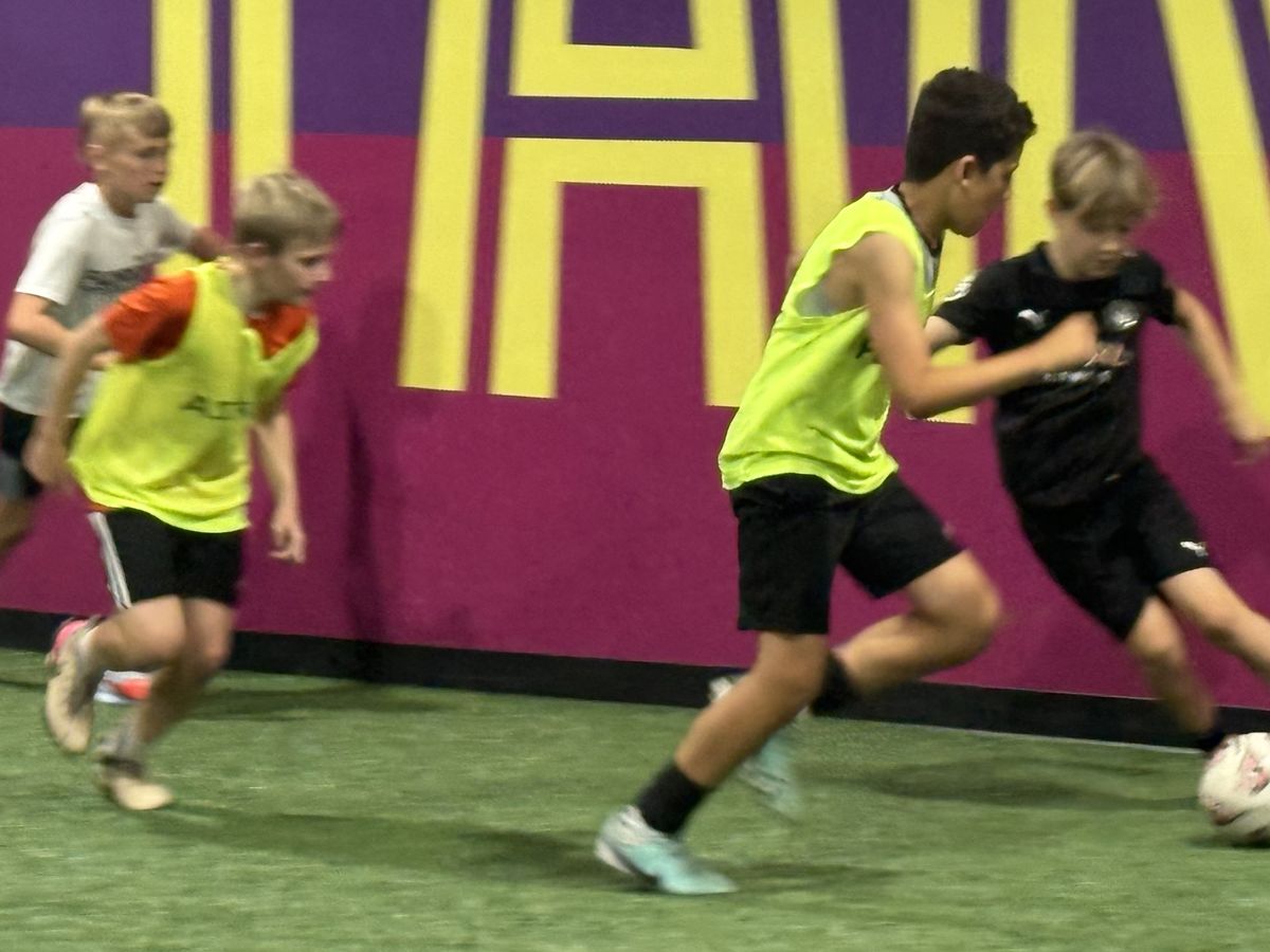 Small-sided game in progress on the indoor turf at Soccer HQ